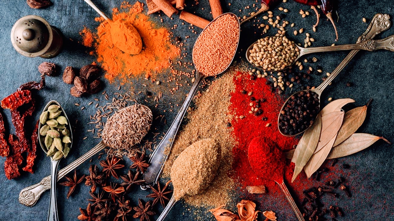 Vibrant spread of spices including turmeric, paprika, cumin, and star anise